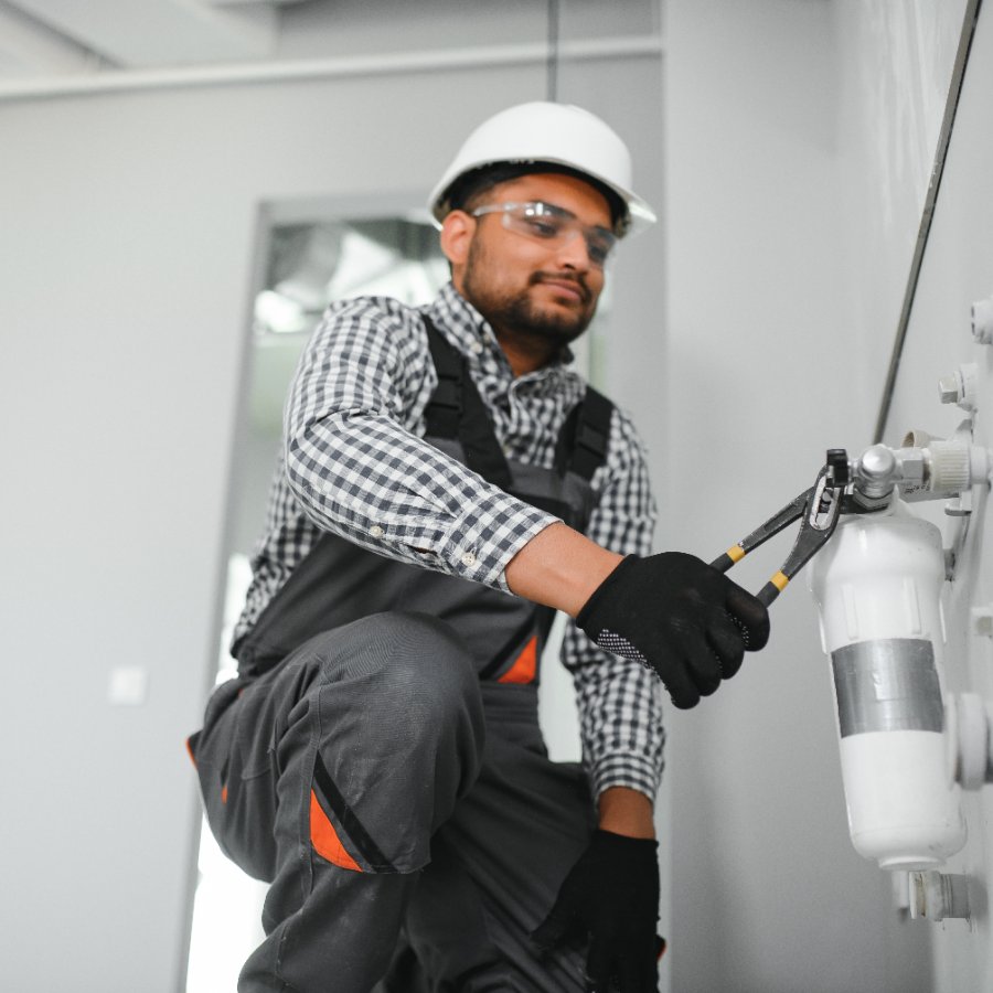 Technician tightening a whole-home water filter cartridge housing