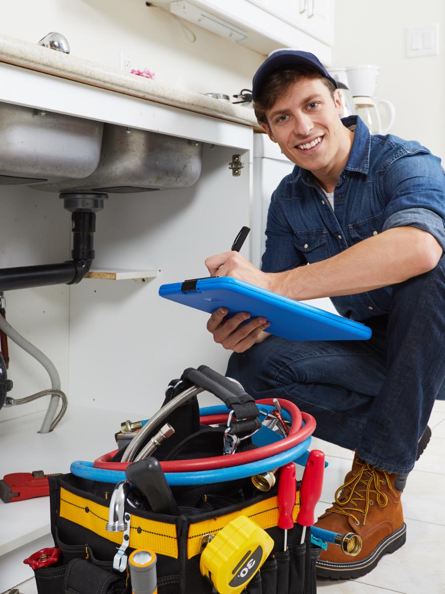 Licensed plumber recording an under-sink inspection at a Riverside home